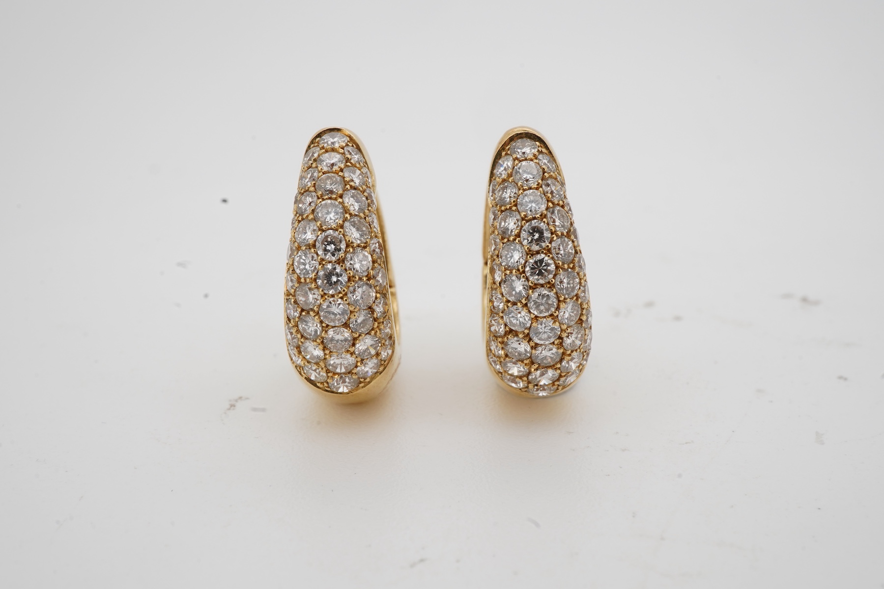 A pair of diamond sleeper earrings, of hinged design, the fronts pavé-set with brilliant-cut diamonds totalling approximately 0.80 carats, length 1.6cm each, post fittings, combined gross weight 6.5 grams